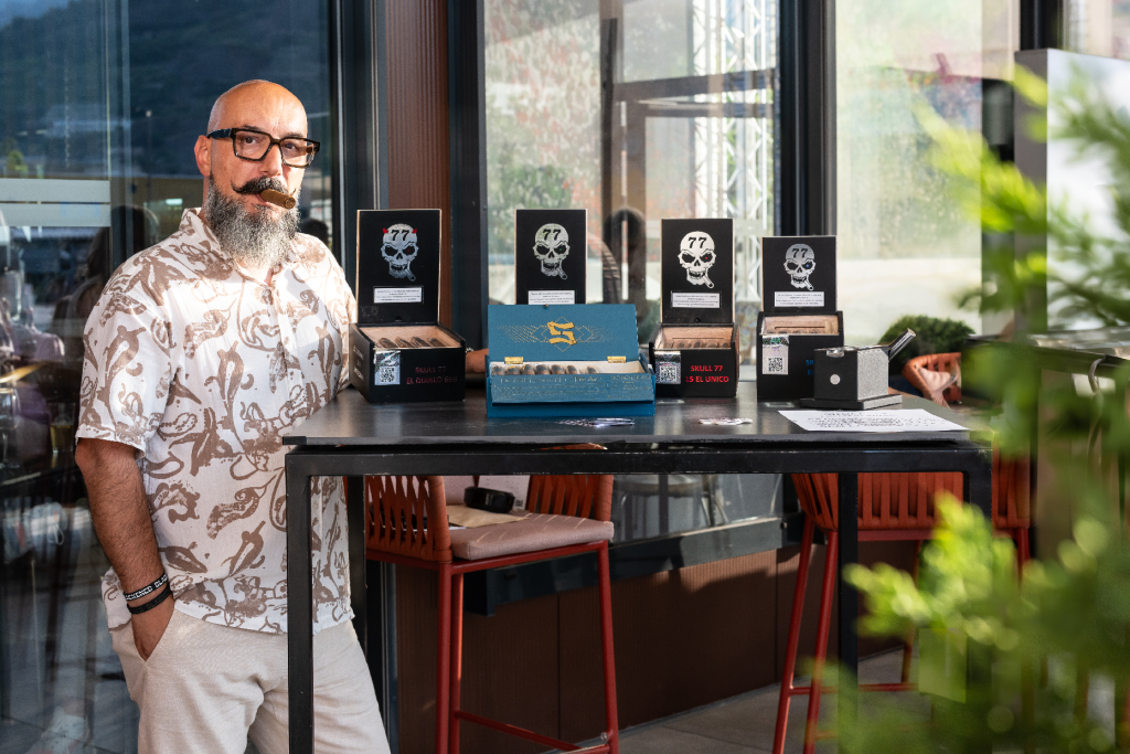 Stéphane Aprille, sommelier du cigare, présentant une sélection de coffrets sur une table, en terrasse